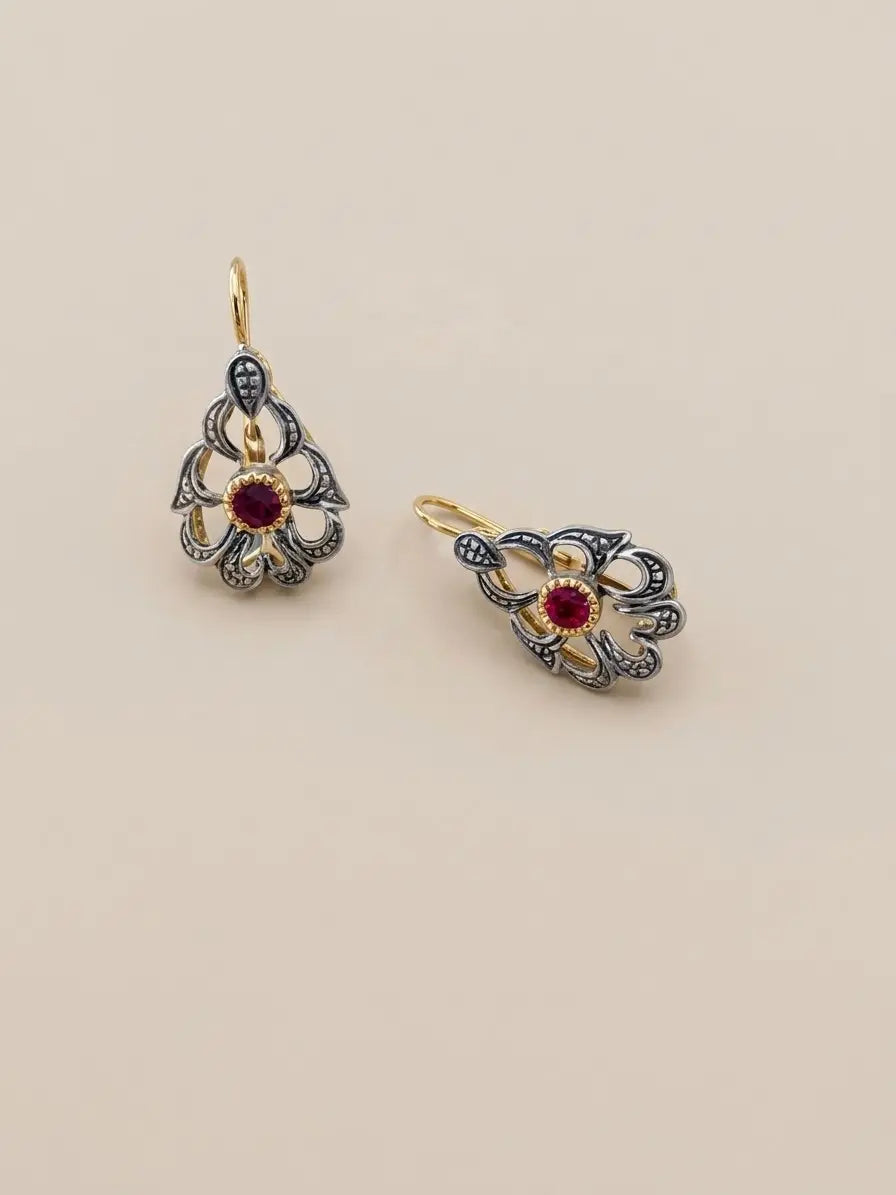 Orecchini pendenti OR0163 in argento 925 con disegno traforato, pietra rossa centrale e dettagli di colore dorato su sfondo neutro, CICCO Gioielleria.