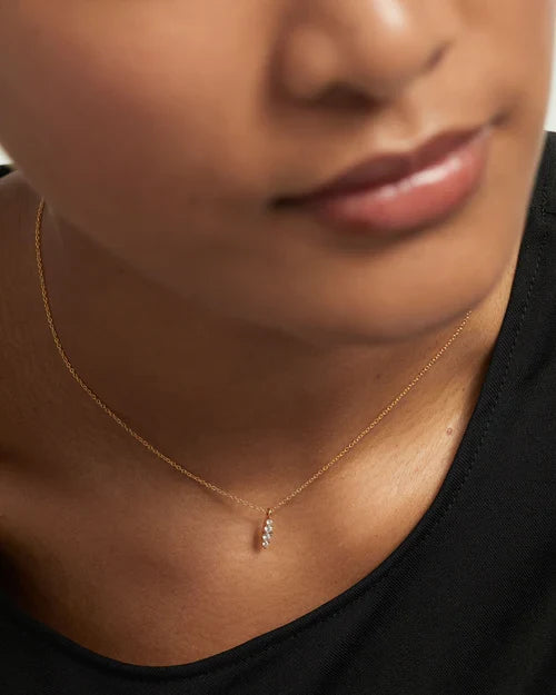 Collana PDPAOLA Vanilla CO01-675 indossata, con piccolo pendente luminoso e catena dorata su maglia nera.