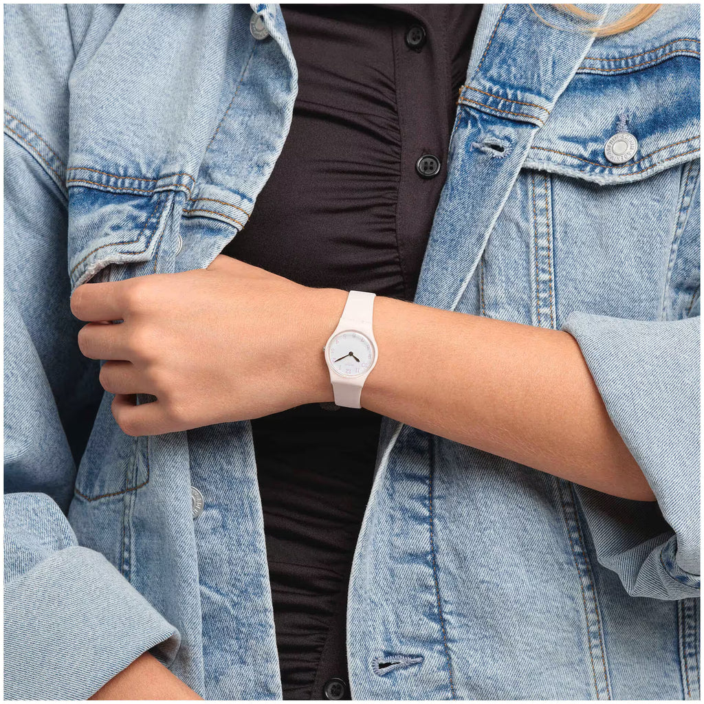 Swatch PINKBELLE LP150 rosa indossato al polso con una giacca in denim.