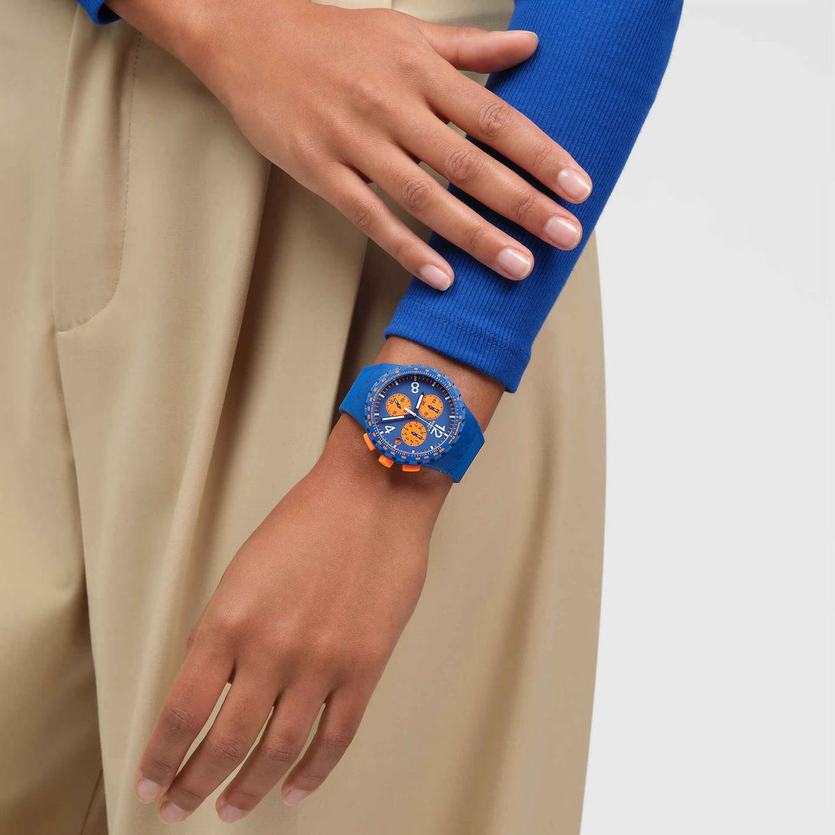 Swatch PRIMARILY BLUE SUSN419 indossato al polso, cronografo blu e arancione abbinato a un look casual.