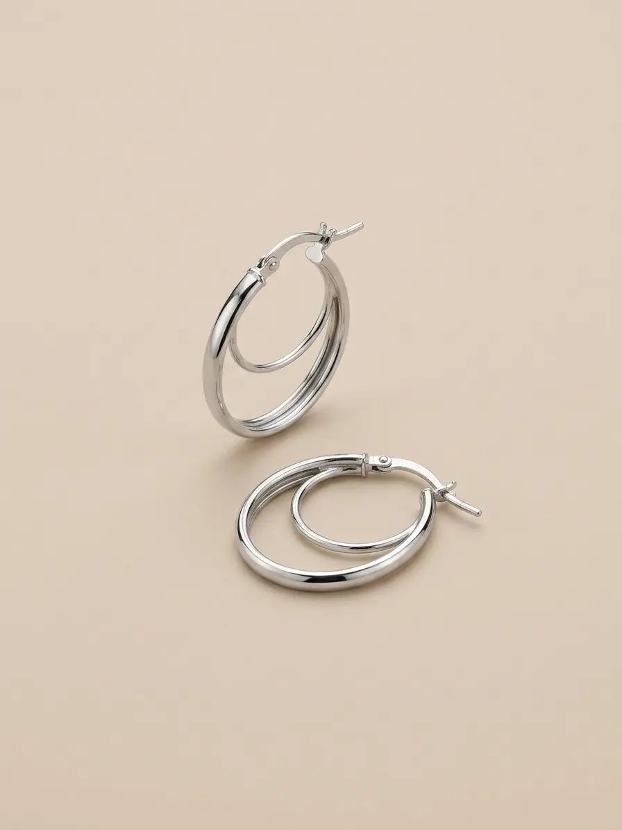 Orecchini a cerchio ovali OR0165 in argento 925 lucido con doppio profilo su fondo neutro, CICCO Gioielleria.