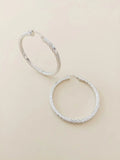 Orecchini a cerchio rigati OR0166 in argento 925 con motivo obliquo a spirale su fondo neutro, CICCO Gioielleria.