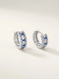 Orecchini a cerchio OR0157 in argento 925 con zirconi blu, pietre bianche e chiusura a scatto, su sfondo chiaro. CICCO Gioielleria.