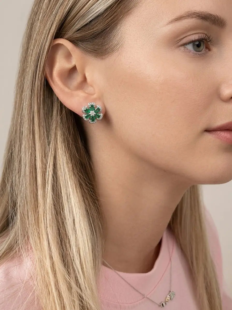 Orecchino a fiore OR0130 con pietre verdi e zirconi bianchi indossato al lobo, con capelli dietro l’orecchio.