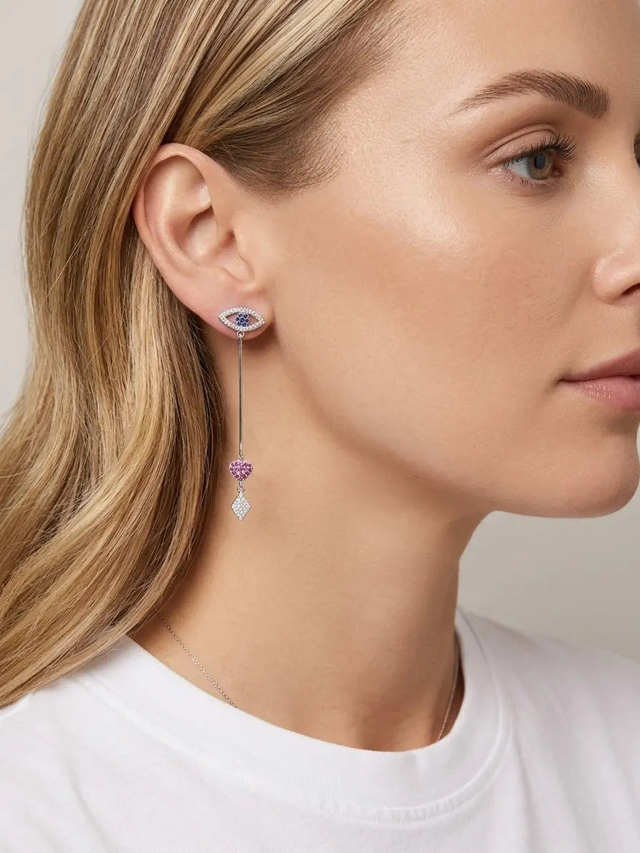Orecchino pendente lineare OR0139 in argento 925 indossato, con occhio blu al lobo, cuore rosa e rombo luminoso, vista laterale, CICCO Gioielleria.