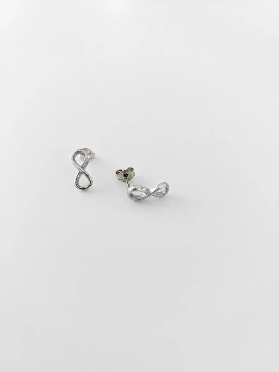 Orecchini infinito in argento 925 OR0125 su sfondo neutro, con superficie liscia e chiusura a farfallina, CICCO Gioielleria.