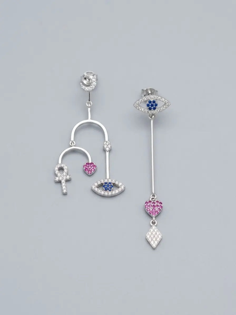 Orecchini pendenti asimmetrici OR0139 in argento 925 con simboli a occhio, cuore, croce ansata e rombo, con pietre blu e rosa su sfondo neutro, CICCO Gioielleria.