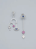 Orecchini pendenti asimmetrici OR0139 in argento 925 con simboli a occhio, cuore, croce ansata e rombo, con pietre blu e rosa su sfondo neutro, CICCO Gioielleria.