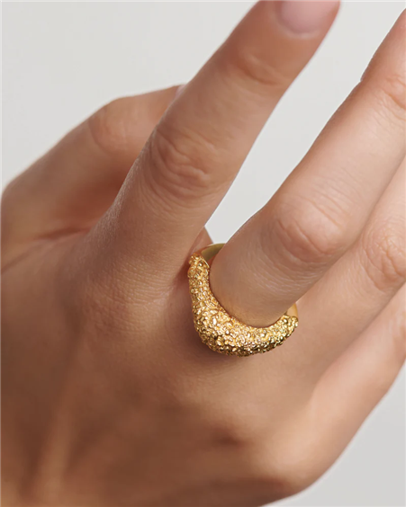 Anello PDPAOLA Duna AN01-B71-14 indossato al dito, con superficie dorata dall’effetto fuso e forma fluida.